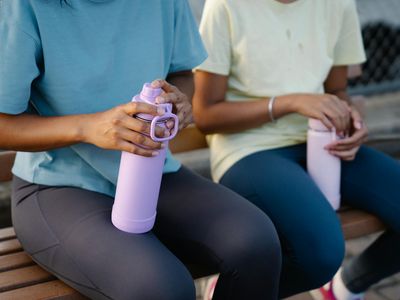 Hands holding a water bottle during a break.